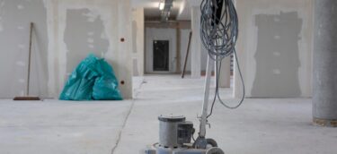 After fit-out cleaning, floor cleaning machine sitting in middle of recently plaster boarded room