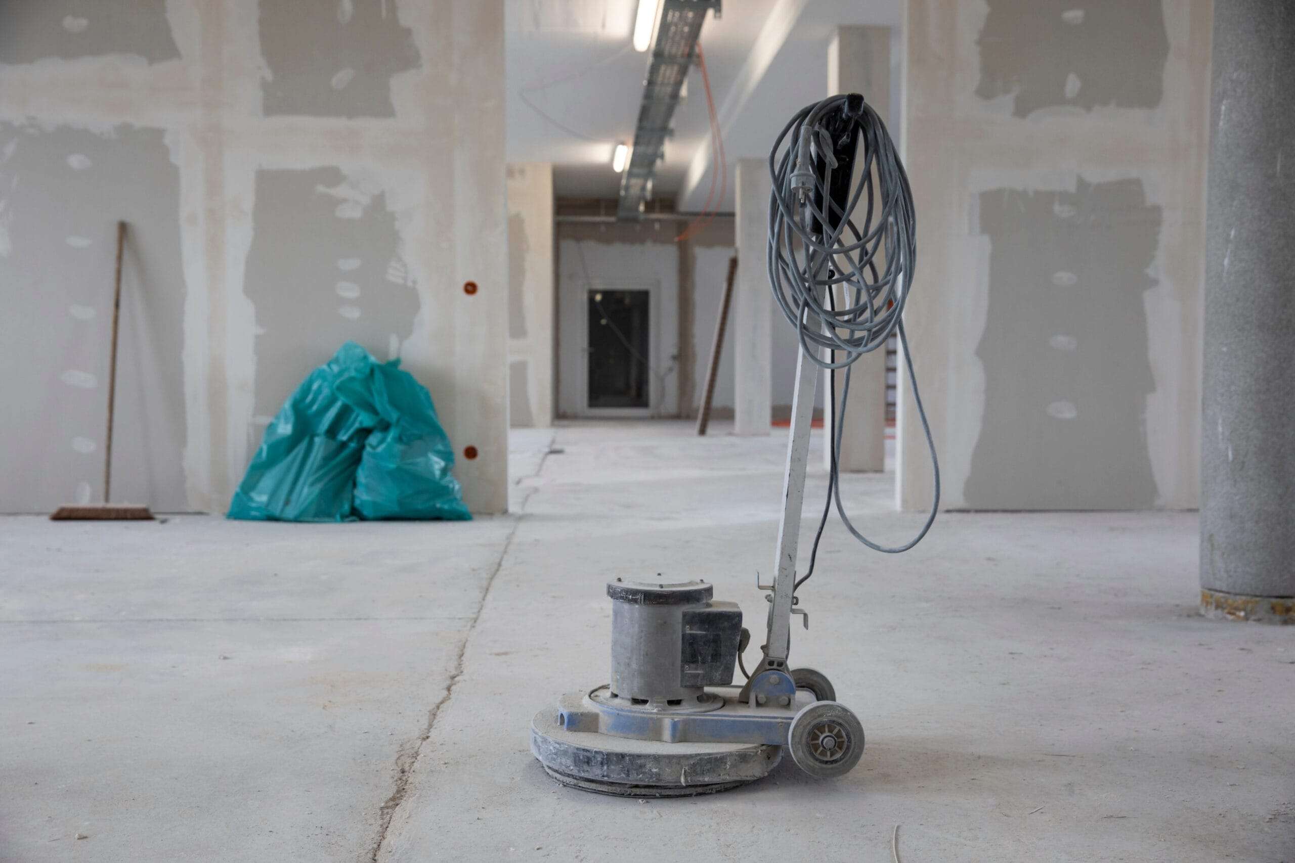 After fit-out cleaning, floor cleaning machine sitting in middle of recently plaster boarded room